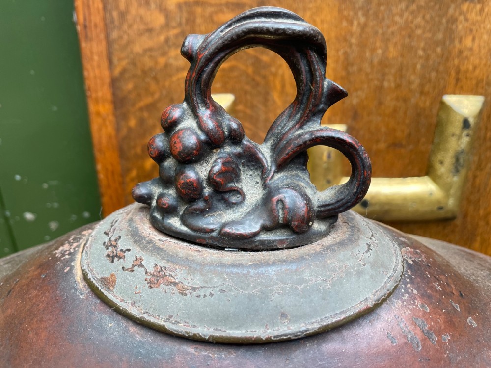 An early nineteenth-century round japanned tinware wine cooler with a domed lid, pedestal base, twin loop handles, and faded painted floral motifs. View XI