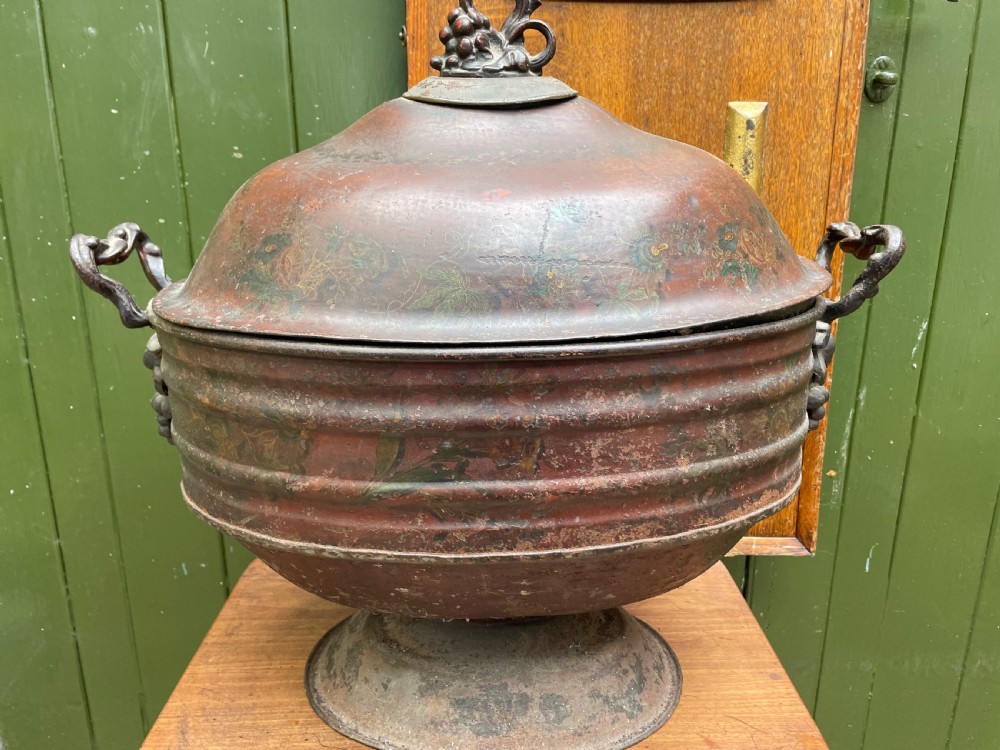An early nineteenth-century round japanned tinware wine cooler with a domed lid, pedestal base, twin loop handles, and faded painted floral motifs. View XIII