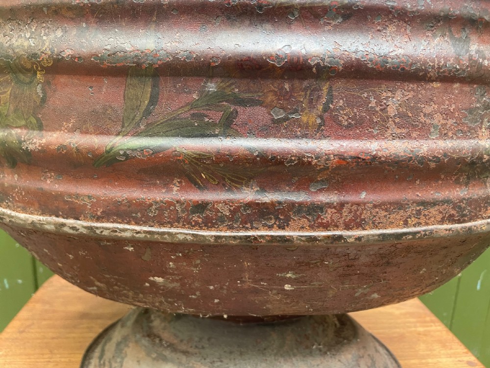 An early nineteenth-century round japanned tinware wine cooler with a domed lid, pedestal base, twin loop handles, and faded painted floral motifs. View XX