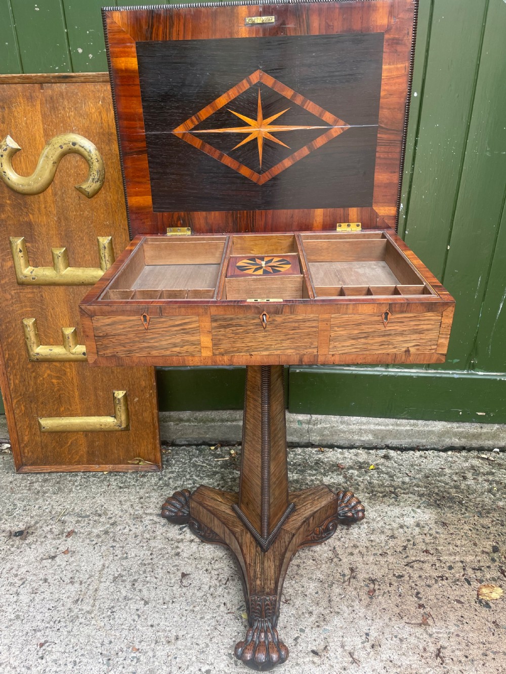 An early nineteenth-century George IV rosewood work table featuring a star-inlaid top, a single drawer casing, a tapered reeded column, and a tripartite base supported by carved claw feet. View VIII