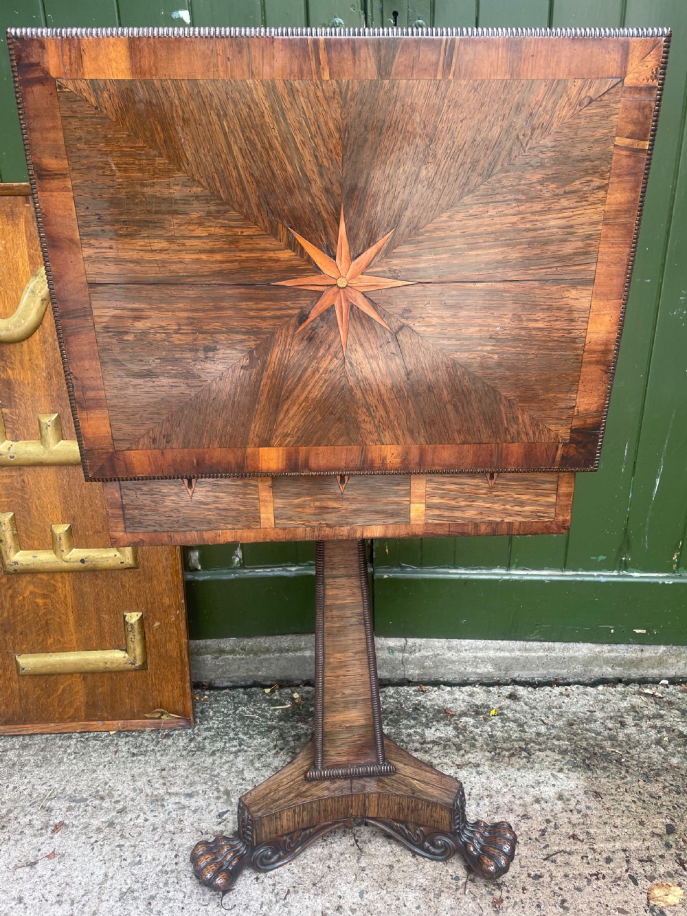 An early nineteenth-century George IV rosewood work table featuring a star-inlaid top, a single drawer casing, a tapered reeded column, and a tripartite base supported by carved claw feet. View XIII