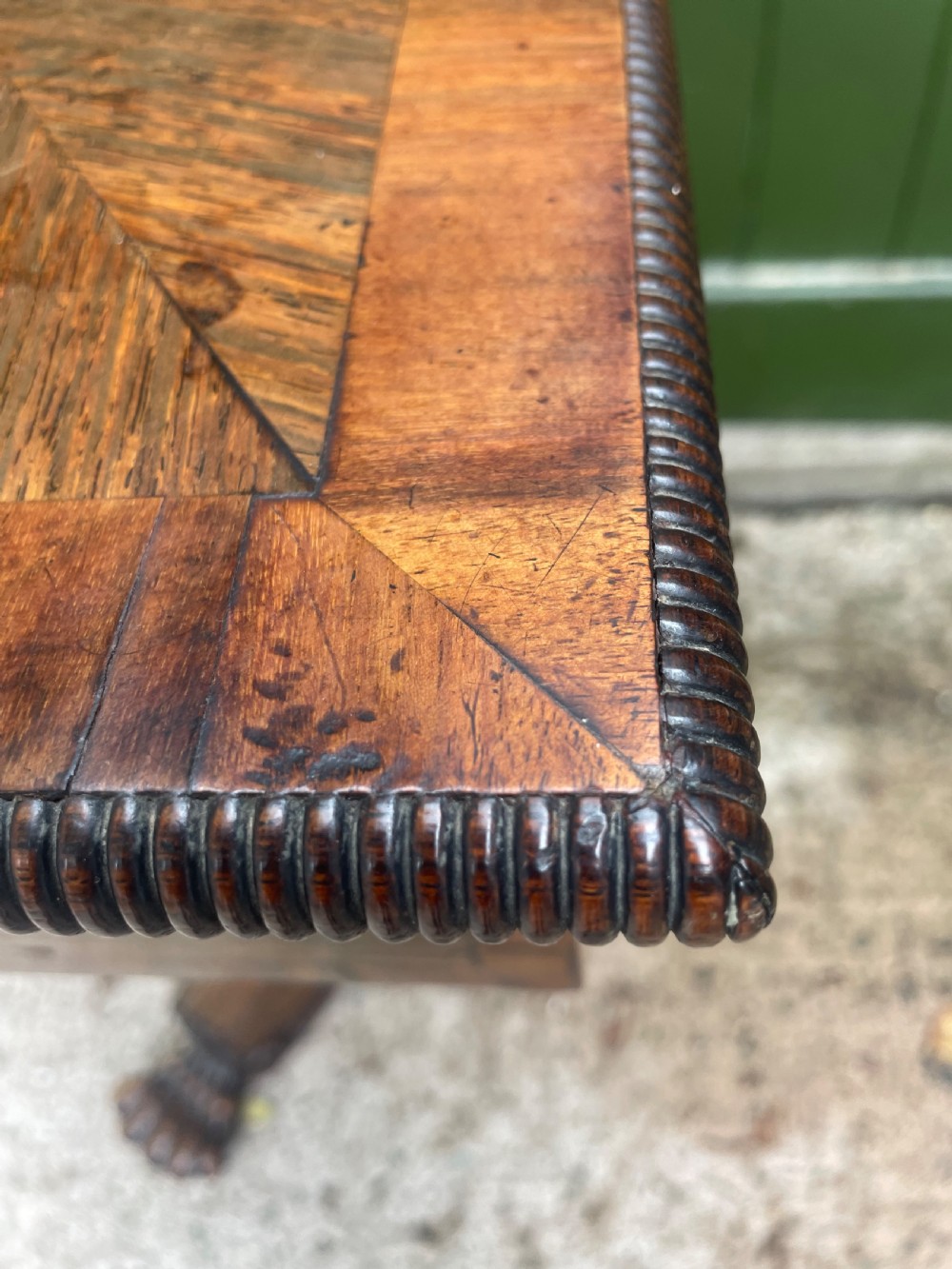 An early nineteenth-century George IV rosewood work table featuring a star-inlaid top, a single drawer casing, a tapered reeded column, and a tripartite base supported by carved claw feet. View XVIII