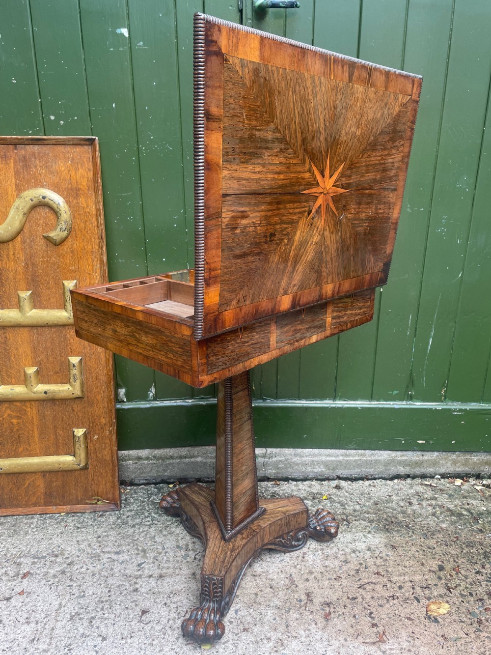 An early nineteenth-century George IV rosewood work table featuring a star-inlaid top, a single drawer casing, a tapered reeded column, and a tripartite base supported by carved claw feet. View XIX