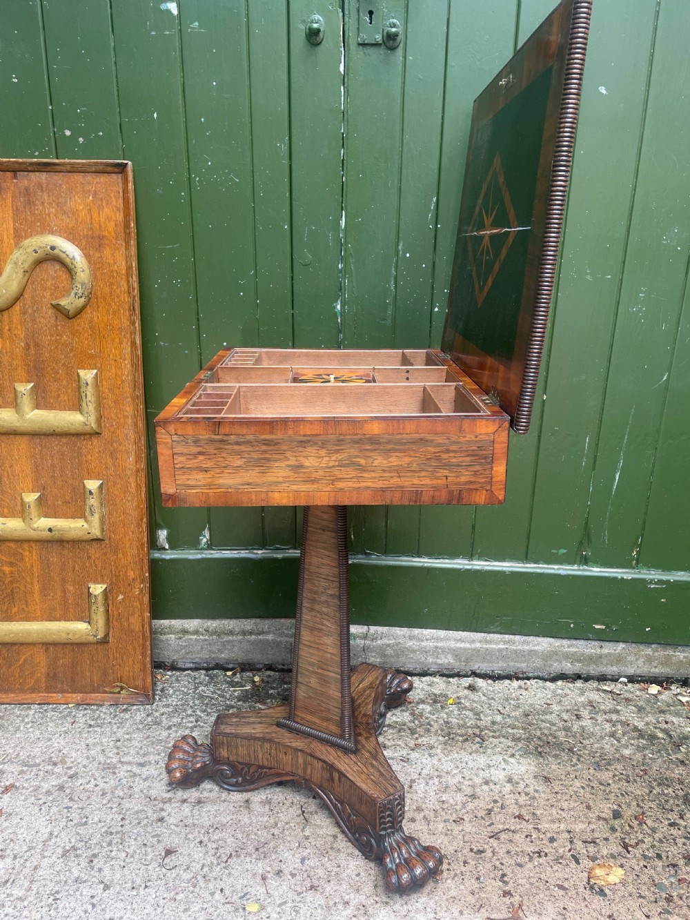 An early nineteenth-century George IV rosewood work table featuring a star-inlaid top, a single drawer casing, a tapered reeded column, and a tripartite base supported by carved claw feet. View XX