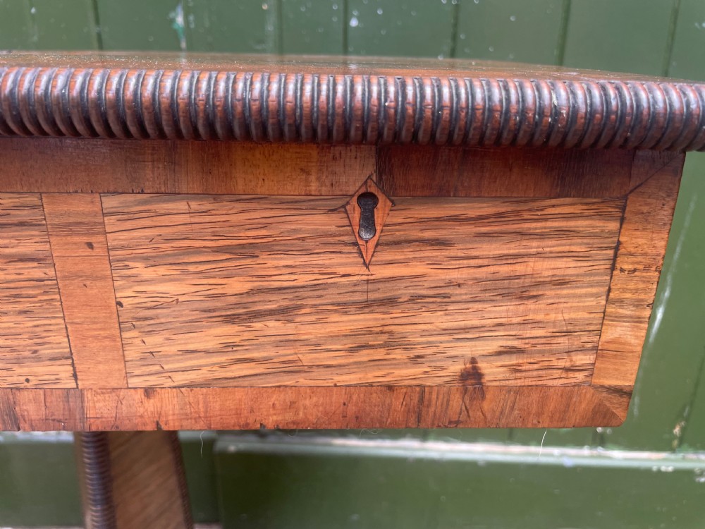 An early nineteenth-century George IV rosewood work table featuring a star-inlaid top, a single drawer casing, a tapered reeded column, and a tripartite base supported by carved claw feet. View XXIV