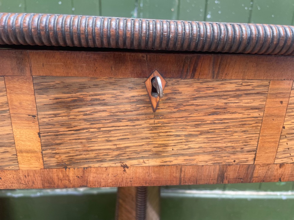An early nineteenth-century George IV rosewood work table featuring a star-inlaid top, a single drawer casing, a tapered reeded column, and a tripartite base supported by carved claw feet. View XXV