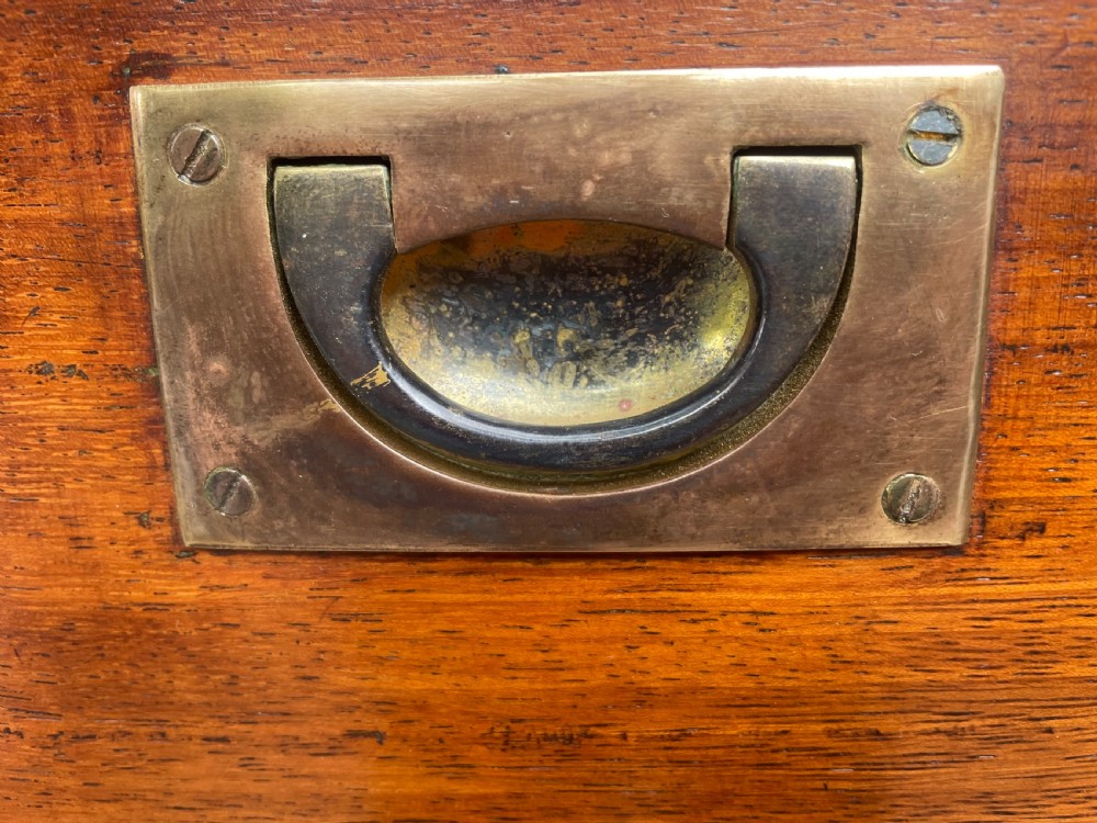 A mid-nineteenth century brass-bound teak campaign chest of drawers featuring two-part construction, recessed brass handles, corner straps, and turned feet. View VII