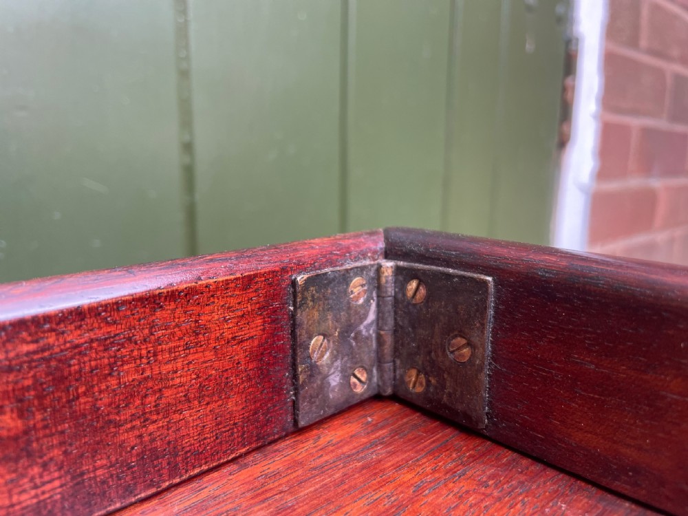 A mid-nineteenth century brass-bound teak campaign chest of drawers featuring two-part construction, recessed brass handles, corner straps, and turned feet. View VIII
