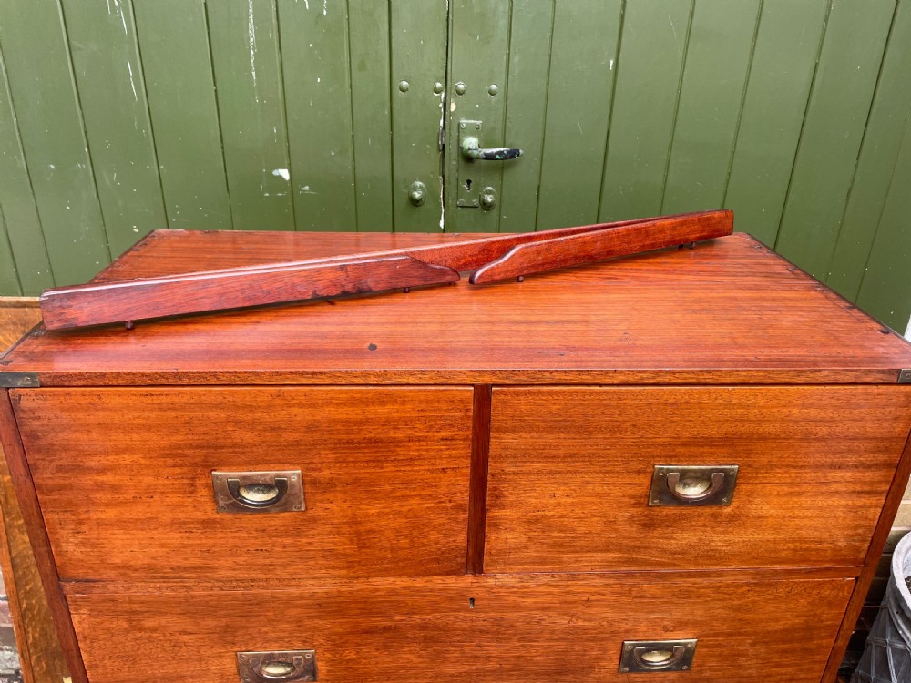 A mid-nineteenth century brass-bound teak campaign chest of drawers featuring two-part construction, recessed brass handles, corner straps, and turned feet. View X