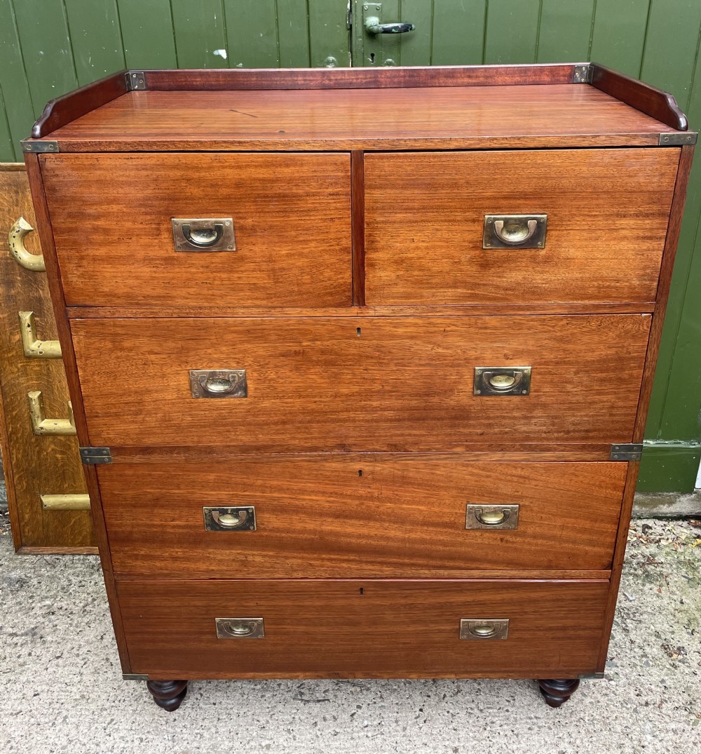A mid-nineteenth century brass-bound teak campaign chest of drawers featuring two-part construction, recessed brass handles, corner straps, and turned feet. View III