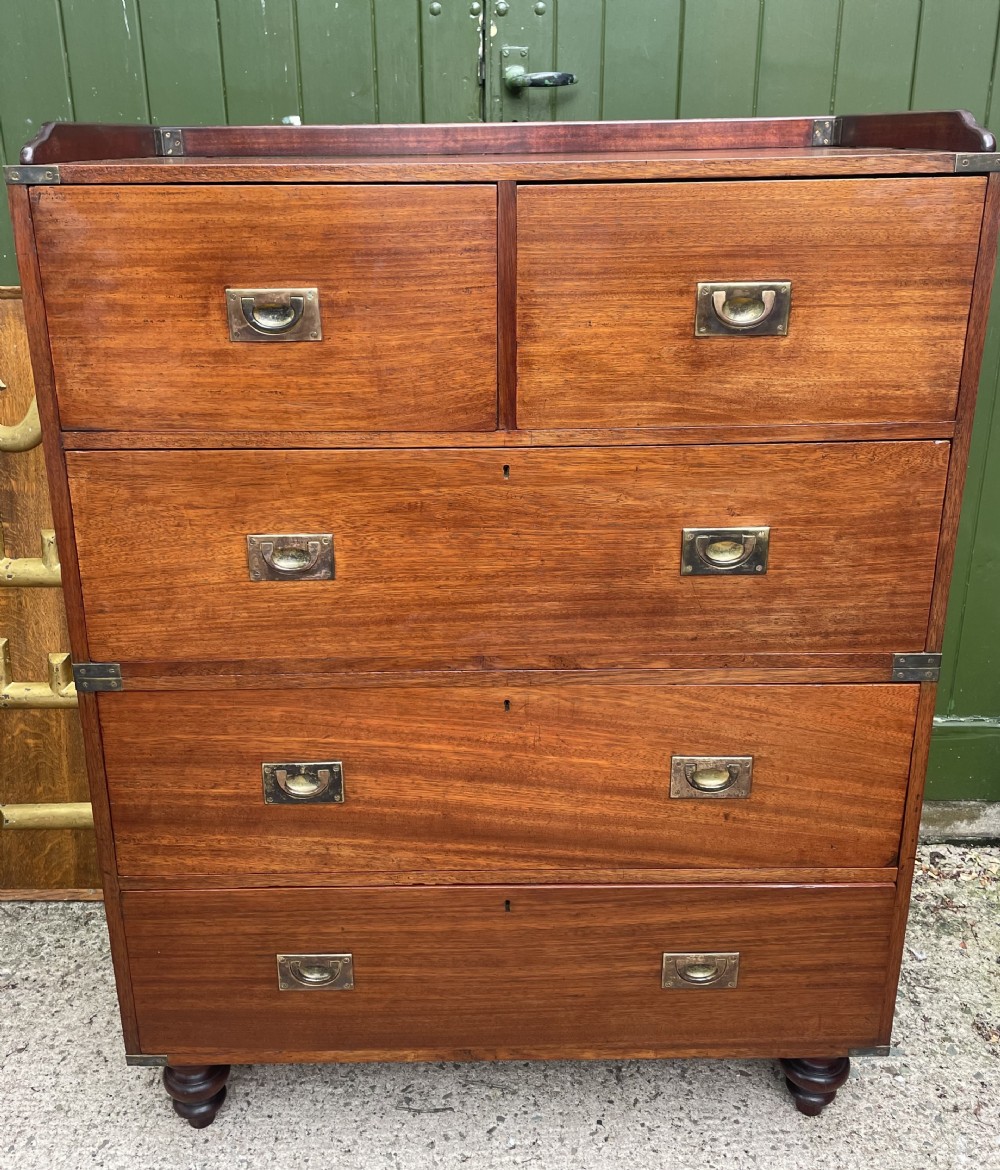 A mid-nineteenth century brass-bound teak campaign chest of drawers featuring two-part construction, recessed brass handles, corner straps, and turned feet. View XX