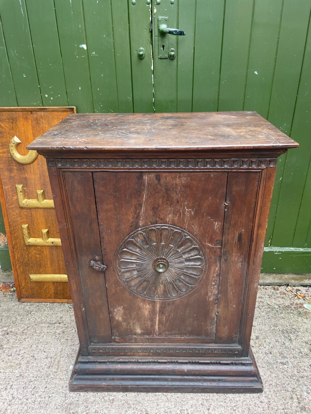 An early 18th-century Italian Tuscan walnut pedestal cupboard featuring a single cupboard door carved with a central circular rosette motif and framed by architectural moulding on a plinth base. View II