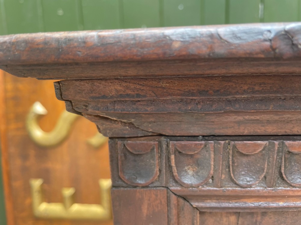 An early 18th-century Italian Tuscan walnut pedestal cupboard featuring a single cupboard door carved with a central circular rosette motif and framed by architectural moulding on a plinth base. View V