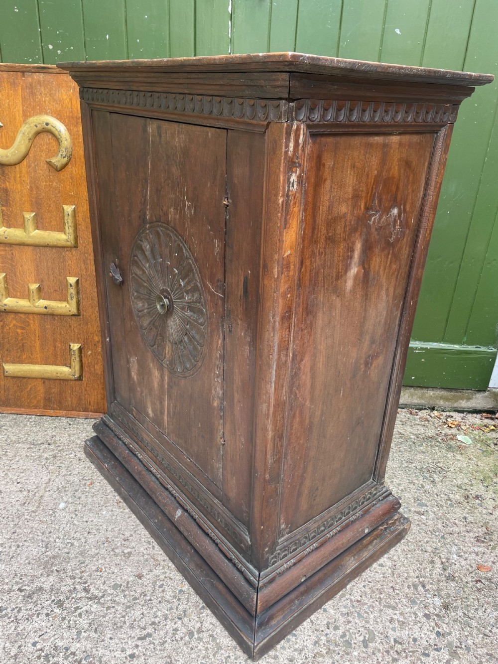 An early 18th-century Italian Tuscan walnut pedestal cupboard featuring a single cupboard door carved with a central circular rosette motif and framed by architectural moulding on a plinth base. View VIII