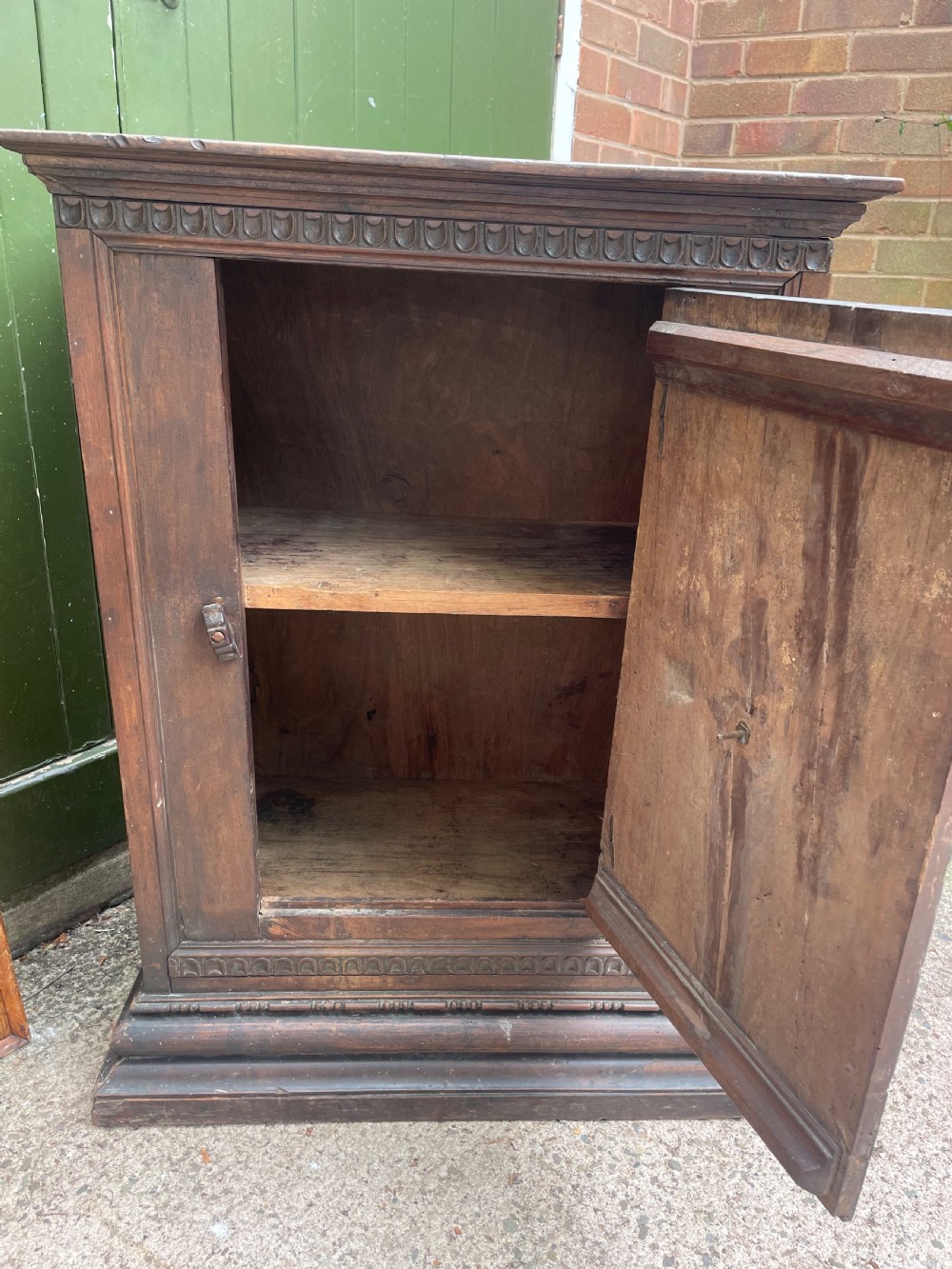 An early 18th-century Italian Tuscan walnut pedestal cupboard featuring a single cupboard door carved with a central circular rosette motif and framed by architectural moulding on a plinth base. View XII