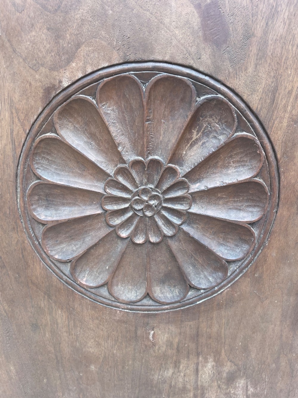 An early 18th-century Italian Tuscan walnut pedestal cupboard featuring a single cupboard door carved with a central circular rosette motif and framed by architectural moulding on a plinth base. View XIV