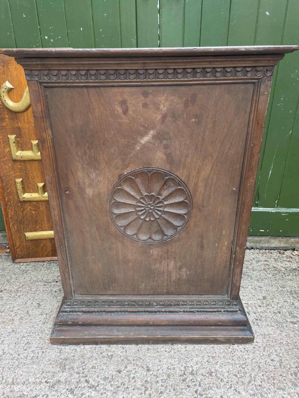 An early 18th-century Italian Tuscan walnut pedestal cupboard featuring a single cupboard door carved with a central circular rosette motif and framed by architectural moulding on a plinth base. View XV