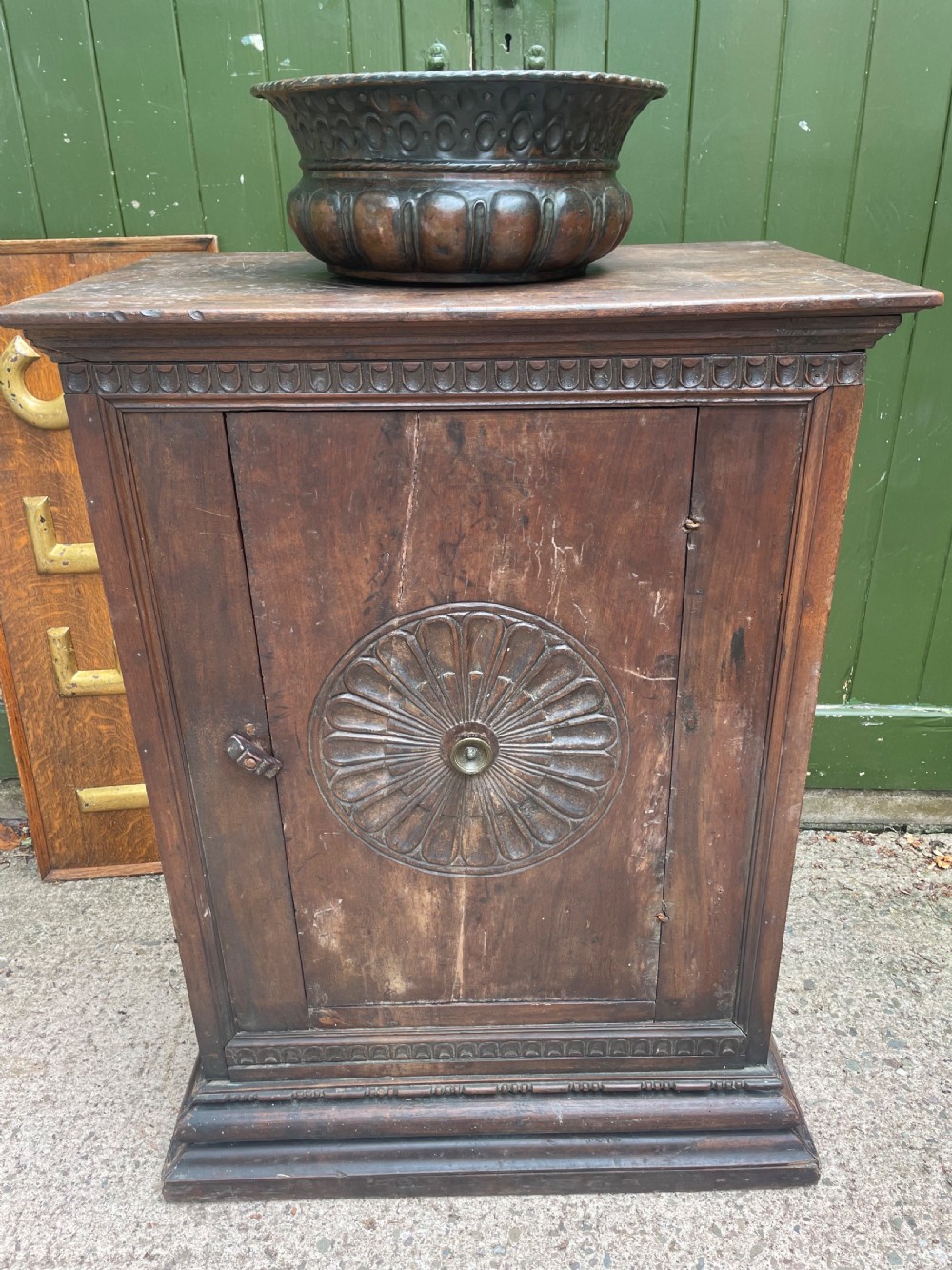 An early 18th-century Italian Tuscan walnut pedestal cupboard featuring a single cupboard door carved with a central circular rosette motif and framed by architectural moulding on a plinth base. View XVII