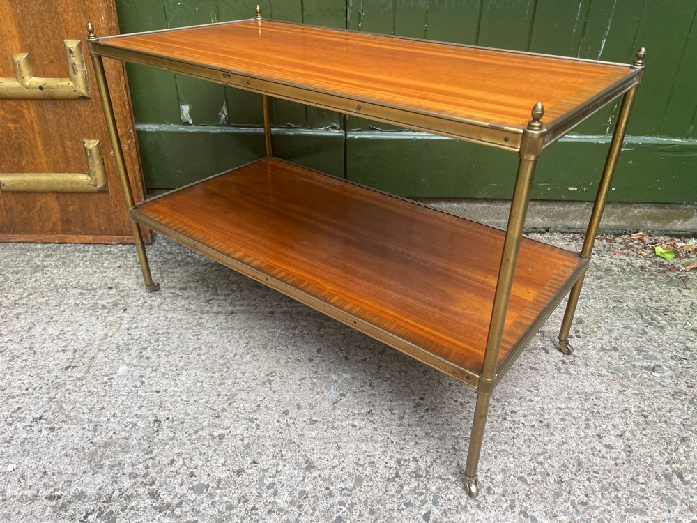 A low rectangular two-tier etagere table featuring satinwood shelves with decorative crossbanded inlay and a brass frame on castors. View VIII