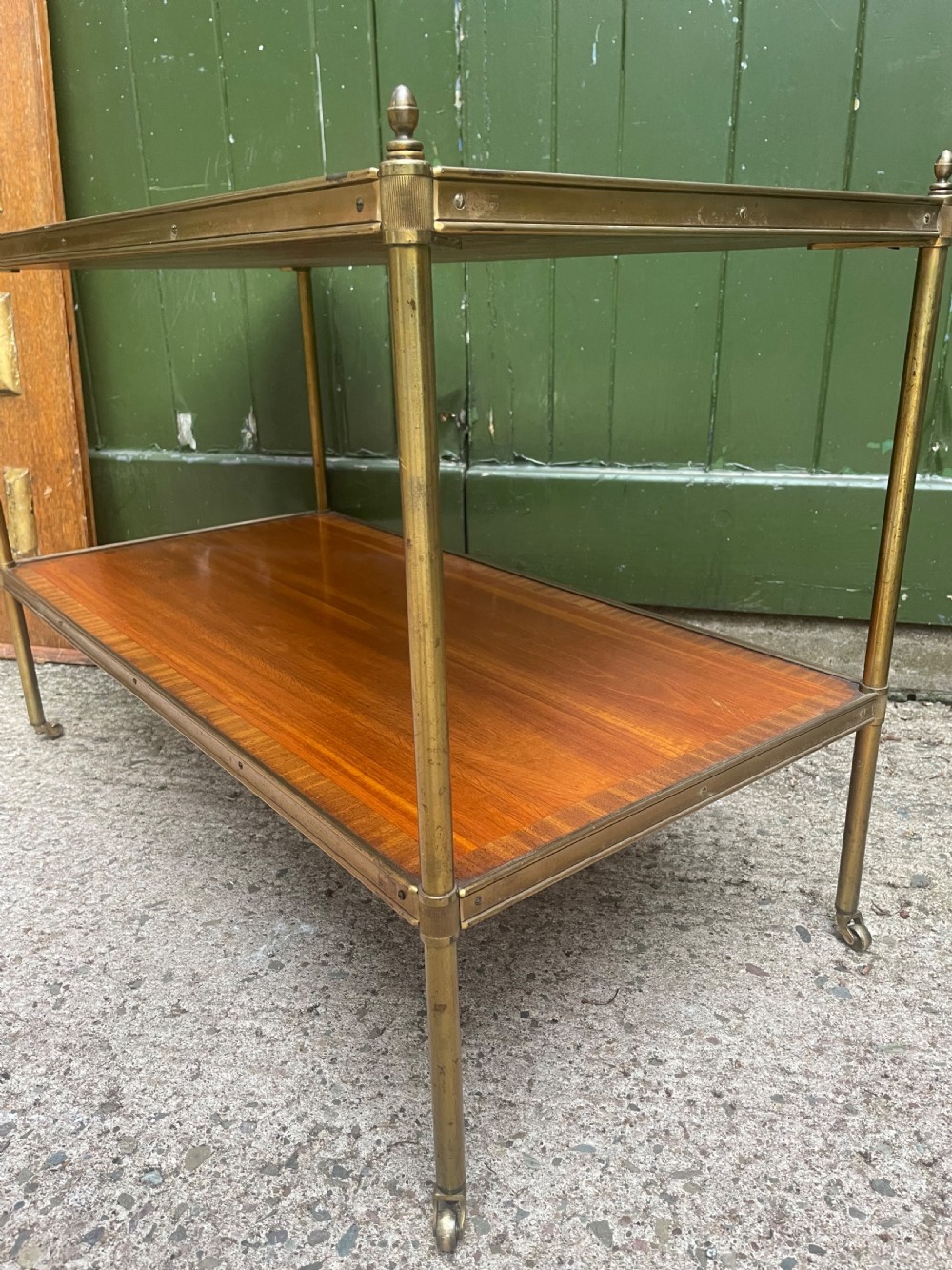 A low rectangular two-tier etagere table featuring satinwood shelves with decorative crossbanded inlay and a brass frame on castors. View XI