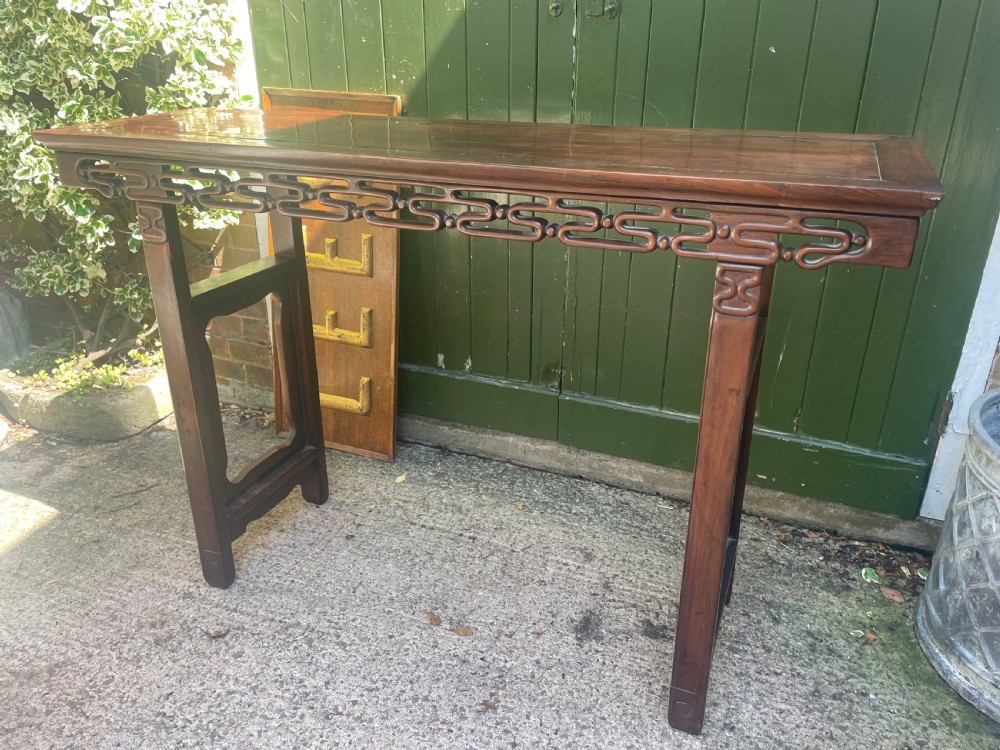 A late nineteenth-century Chinese carved hardwood altar table with an openwork apron and straight legs. View V
