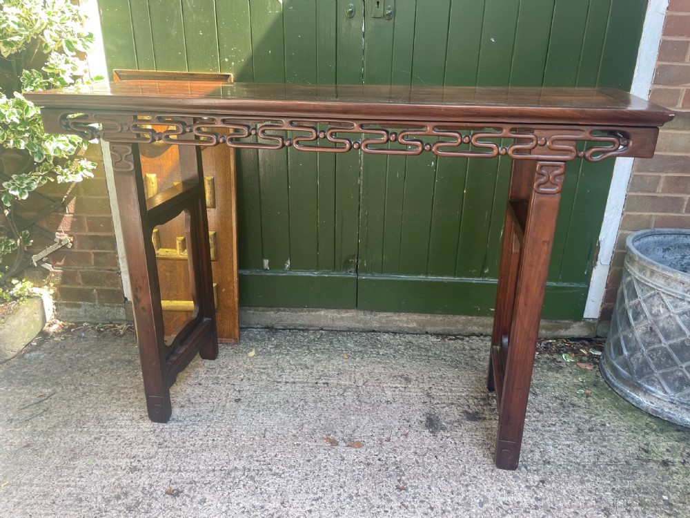 A late nineteenth-century Chinese carved hardwood altar table with an openwork apron and straight legs. View IX