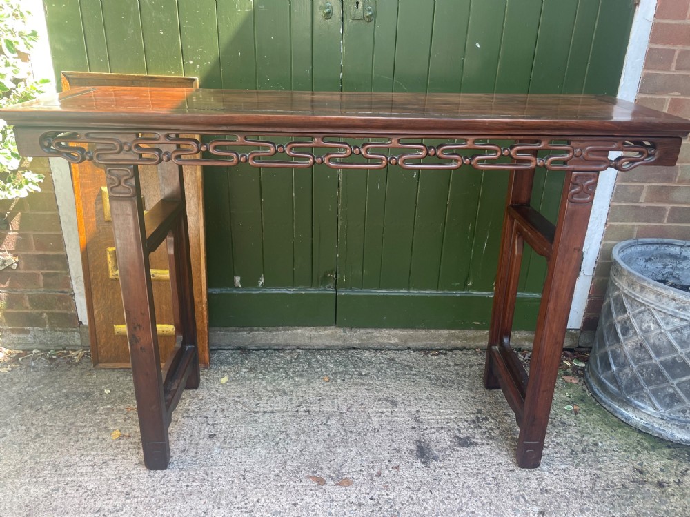 A late nineteenth-century Chinese carved hardwood altar table with an openwork apron and straight legs. View X