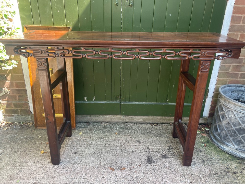 A late nineteenth-century Chinese carved hardwood altar table with an openwork apron and straight legs. View XVI