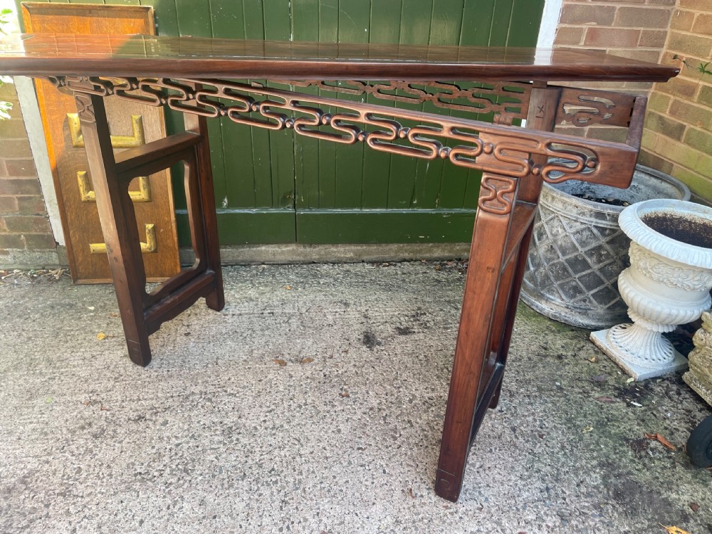A late nineteenth-century Chinese carved hardwood altar table with an openwork apron and straight legs. View XIX