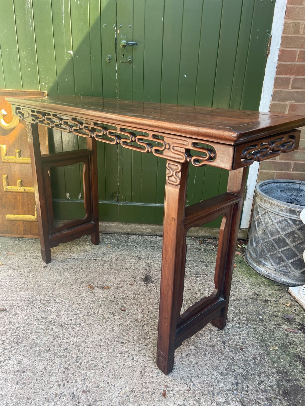 A late nineteenth-century Chinese carved hardwood altar table with an openwork apron and straight legs. View XX