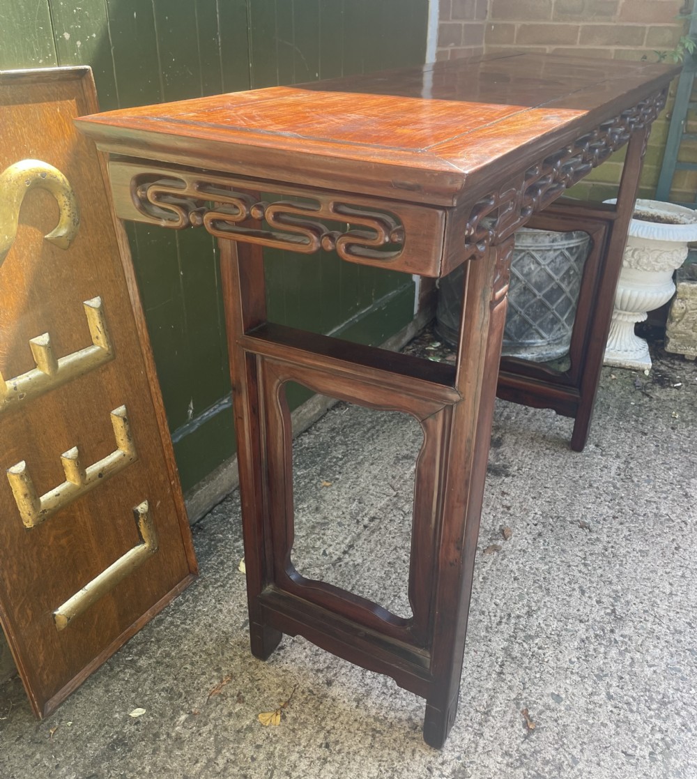 A late nineteenth-century Chinese carved hardwood altar table with an openwork apron and straight legs. View XXVIII