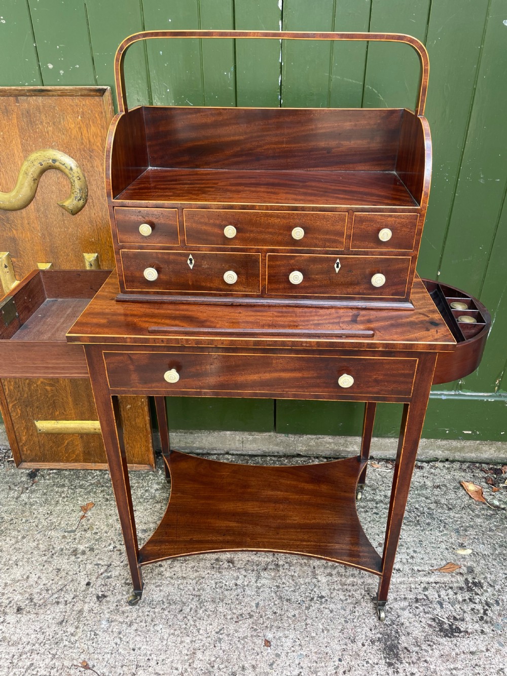 A late 18th-century George III Sheraton mahogany cheveret writing desk featuring a removable upper drawer section with an arched handle, line inlay, and tapered square legs on castors. View III