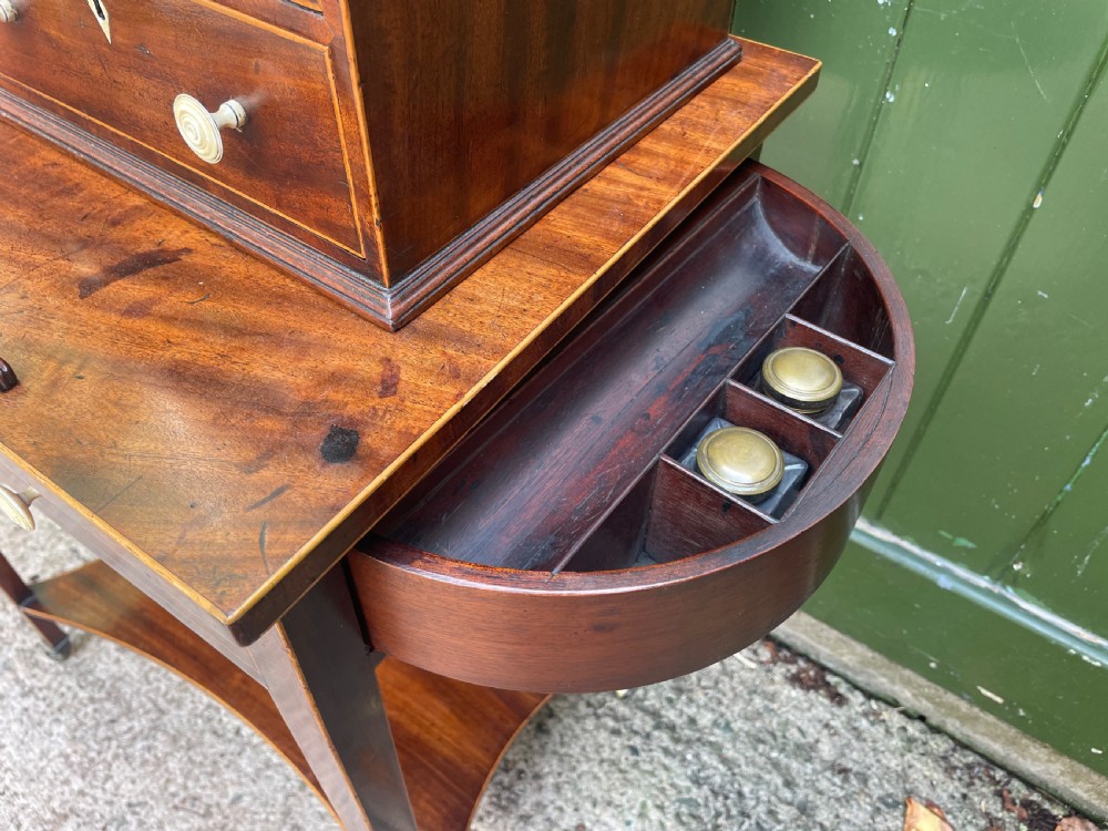 A late 18th-century George III Sheraton mahogany cheveret writing desk featuring a removable upper drawer section with an arched handle, line inlay, and tapered square legs on castors. View IV