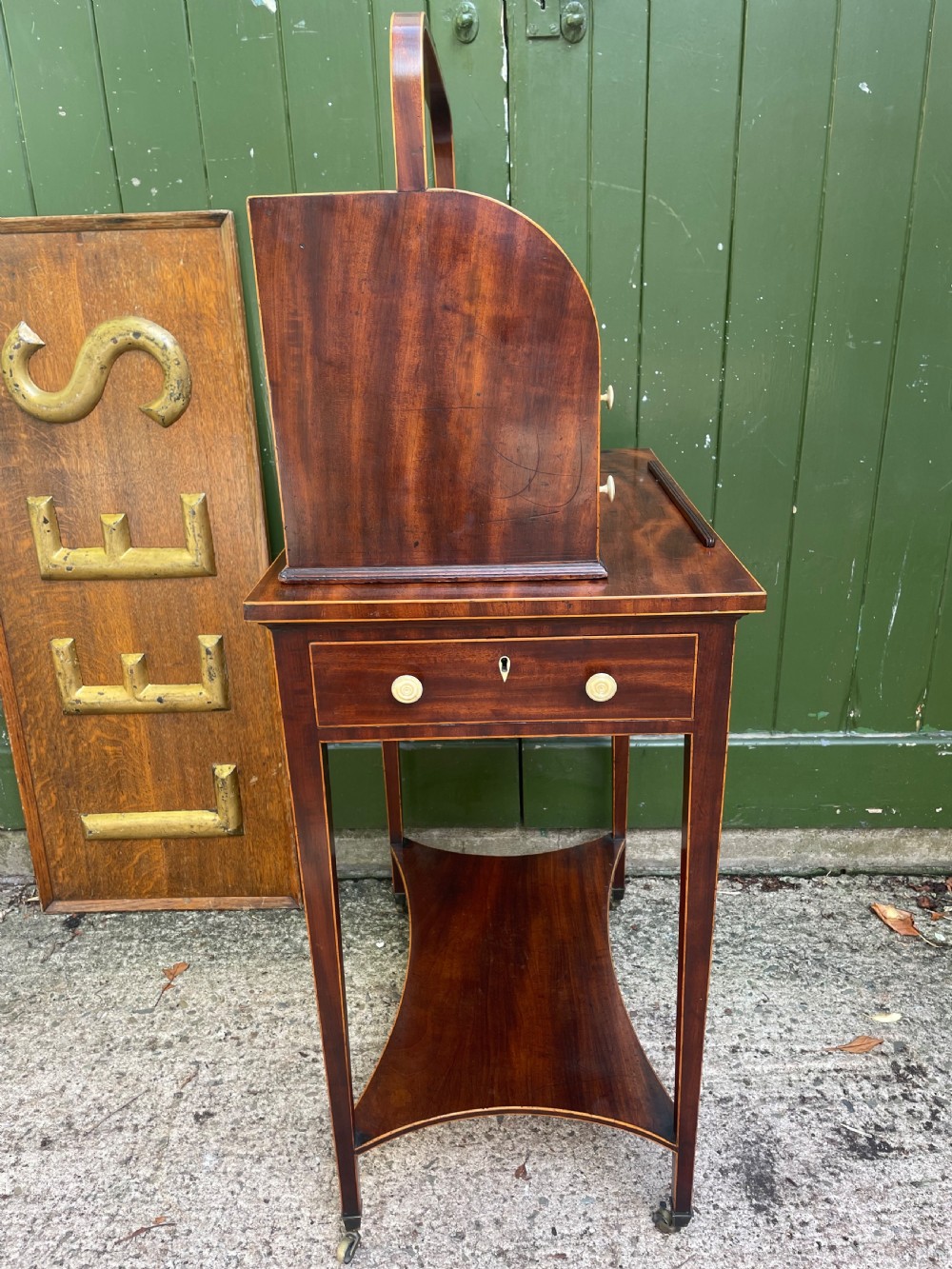 A late 18th-century George III Sheraton mahogany cheveret writing desk featuring a removable upper drawer section with an arched handle, line inlay, and tapered square legs on castors. View XI