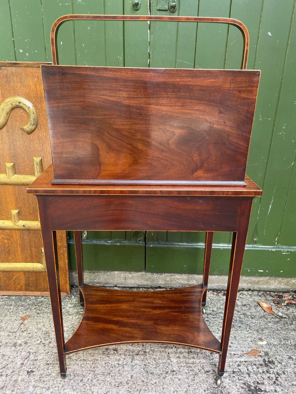 A late 18th-century George III Sheraton mahogany cheveret writing desk featuring a removable upper drawer section with an arched handle, line inlay, and tapered square legs on castors. View XII