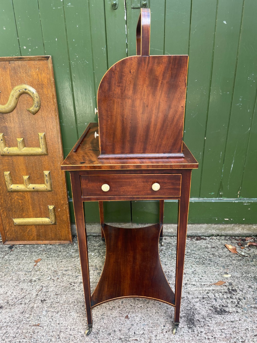 A late 18th-century George III Sheraton mahogany cheveret writing desk featuring a removable upper drawer section with an arched handle, line inlay, and tapered square legs on castors. View XIV