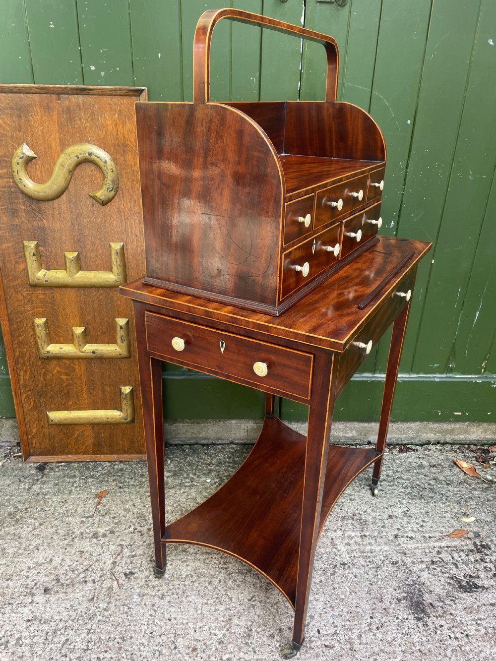 A late 18th-century George III Sheraton mahogany cheveret writing desk featuring a removable upper drawer section with an arched handle, line inlay, and tapered square legs on castors. View XXIII