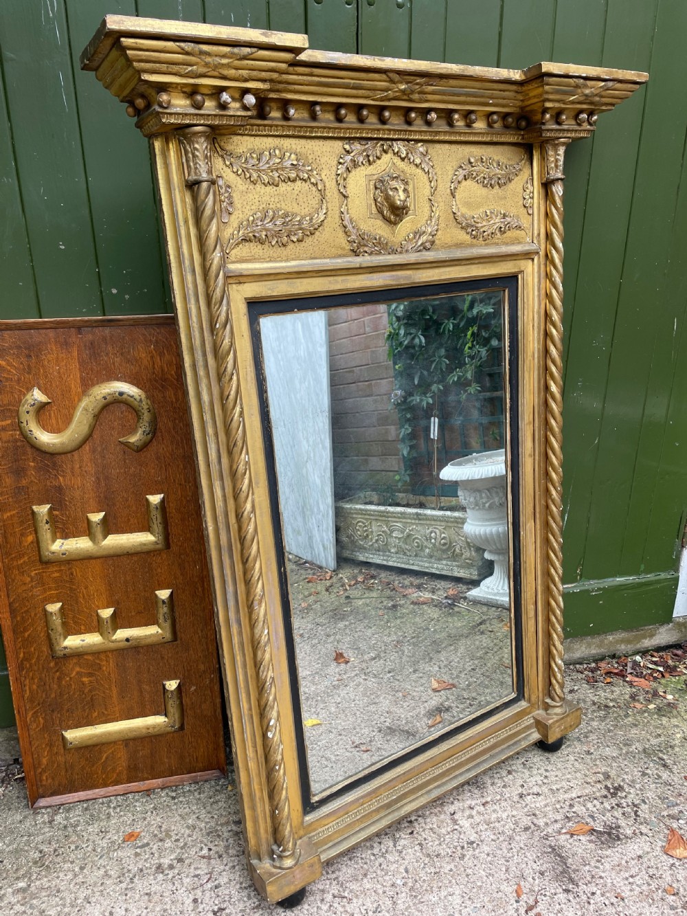 A large nineteenth-century Regency giltwood pier mirror with rope-twist side columns, a lion mask frieze, and an ebonised inner slip.
