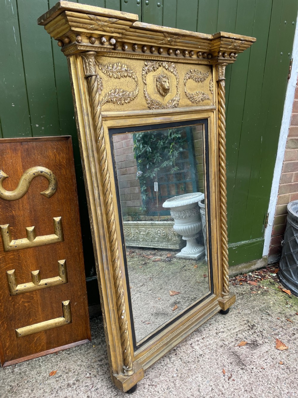 A large nineteenth-century Regency giltwood pier mirror with rope-twist side columns, a lion mask frieze, and an ebonised inner slip. View II