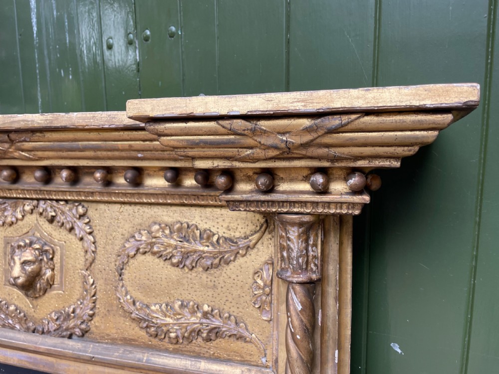 A large nineteenth-century Regency giltwood pier mirror with rope-twist side columns, a lion mask frieze, and an ebonised inner slip. View VI