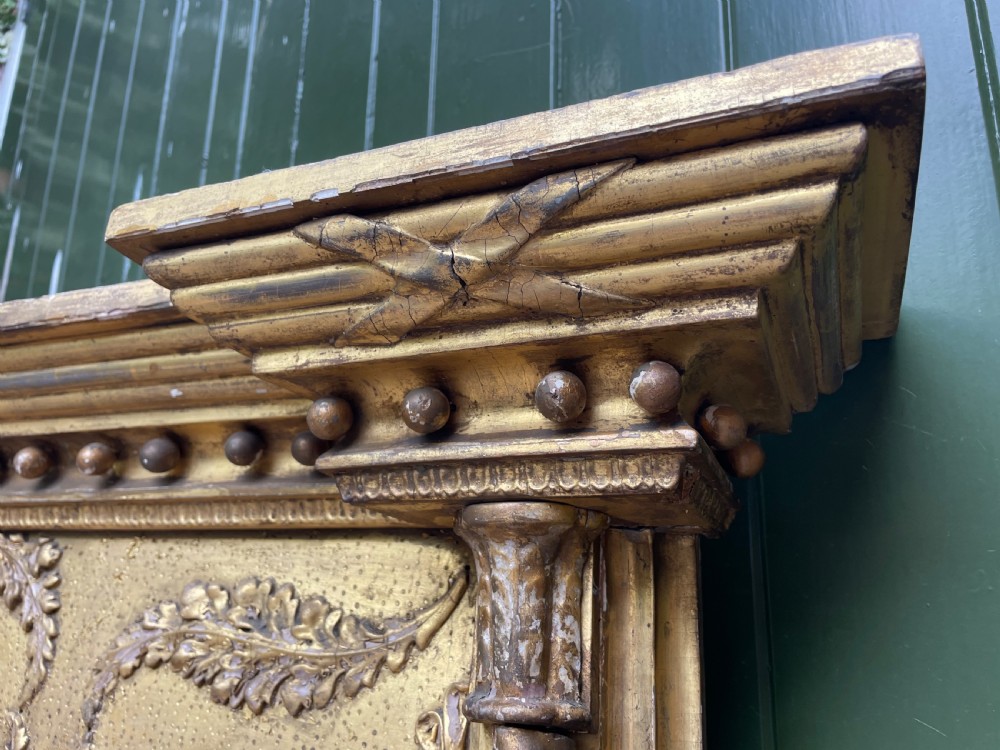 A large nineteenth-century Regency giltwood pier mirror with rope-twist side columns, a lion mask frieze, and an ebonised inner slip. View IX