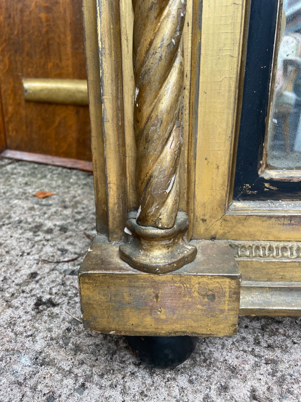 A large nineteenth-century Regency giltwood pier mirror with rope-twist side columns, a lion mask frieze, and an ebonised inner slip. View XI
