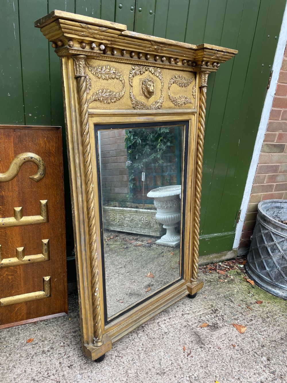 A large nineteenth-century Regency giltwood pier mirror with rope-twist side columns, a lion mask frieze, and an ebonised inner slip. View XII