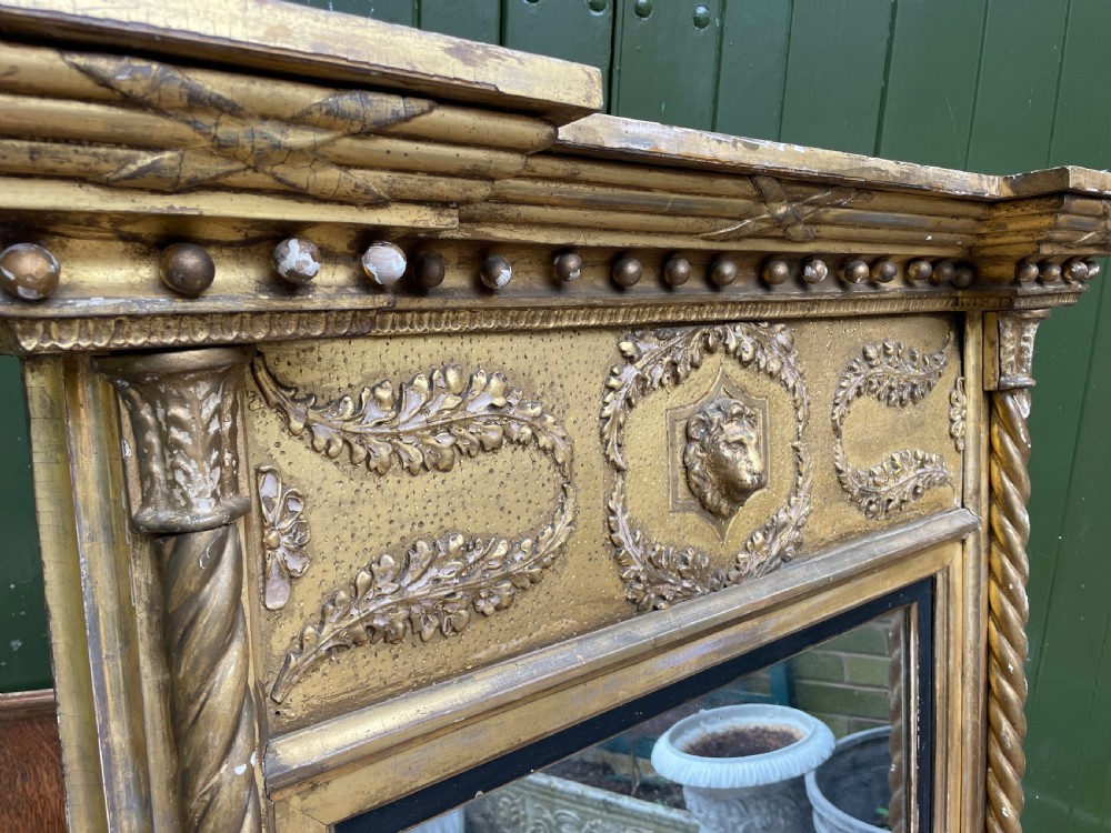 A large nineteenth-century Regency giltwood pier mirror with rope-twist side columns, a lion mask frieze, and an ebonised inner slip. View XIII