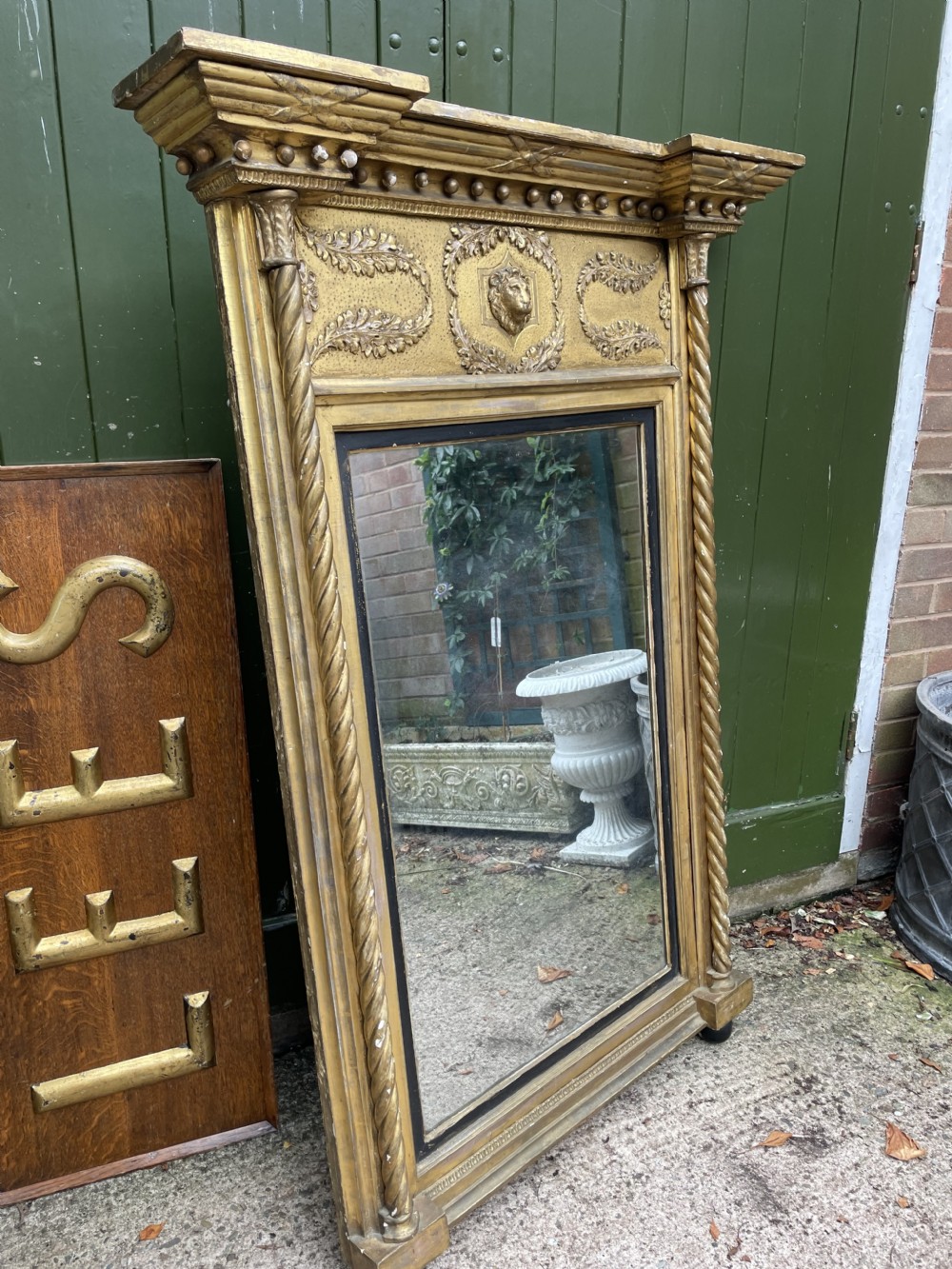 A large nineteenth-century Regency giltwood pier mirror with rope-twist side columns, a lion mask frieze, and an ebonised inner slip. View XIV