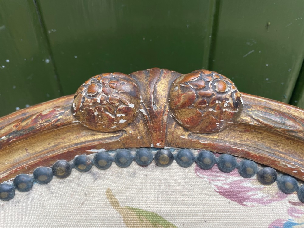 A pair of mid-19th-century French Louis XVI style giltwood salon armchairs with oval backs and floral upholstery. View IV