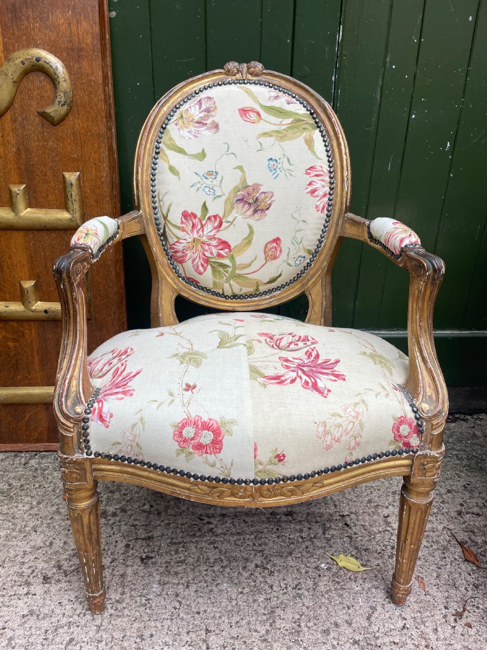 A pair of mid-19th-century French Louis XVI style giltwood salon armchairs with oval backs and floral upholstery. View V