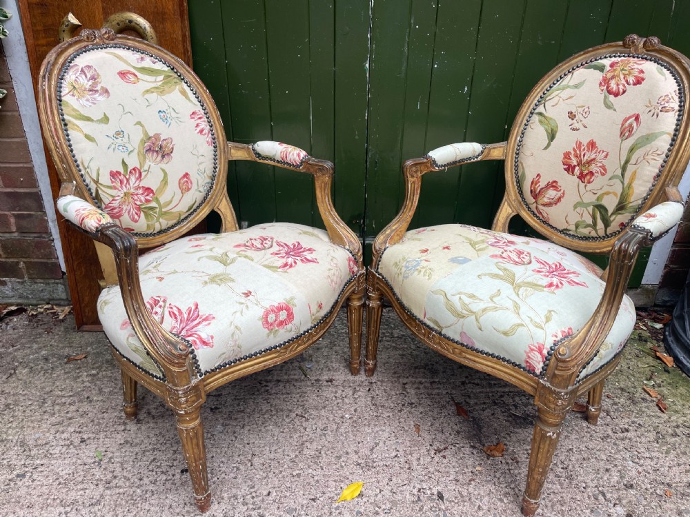 A pair of mid-19th-century French Louis XVI style giltwood salon armchairs with oval backs and floral upholstery. View VII