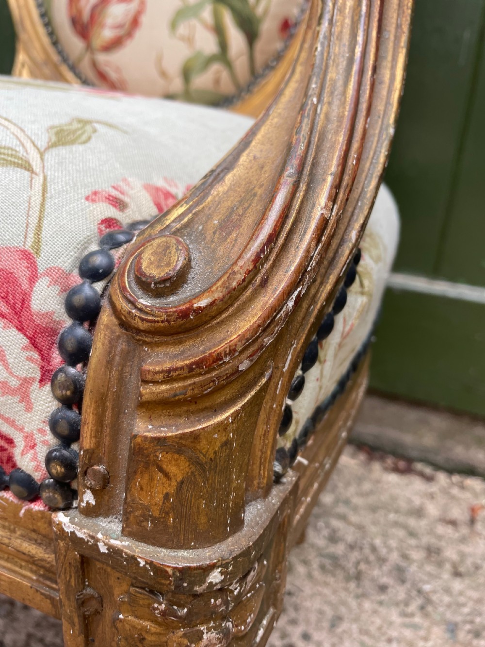 A pair of mid-19th-century French Louis XVI style giltwood salon armchairs with oval backs and floral upholstery. View X