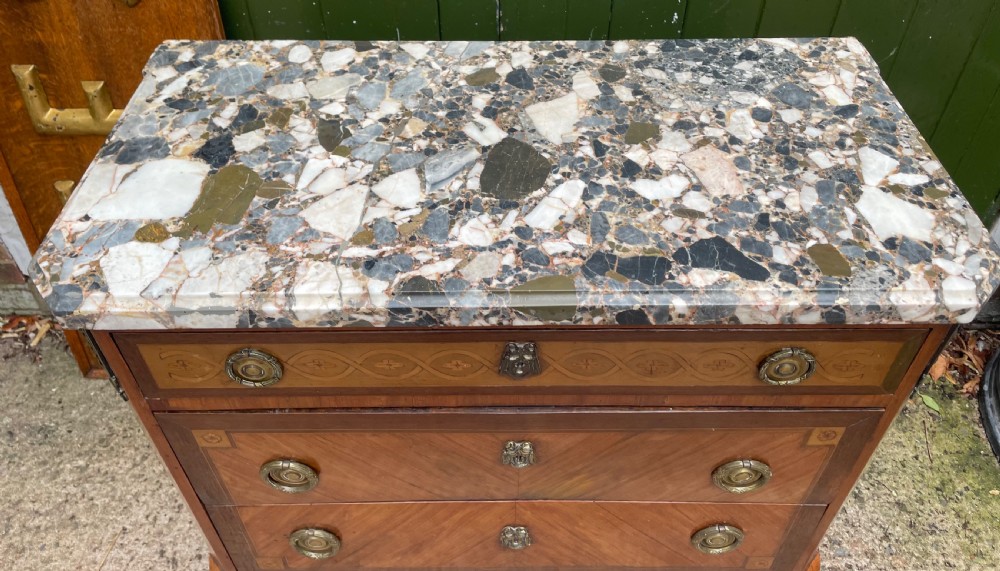 A late nineteenth-century French Louis XVI transitional style commode featuring marquetry wood veneers, brass ring handles, and a grey marble top. View II